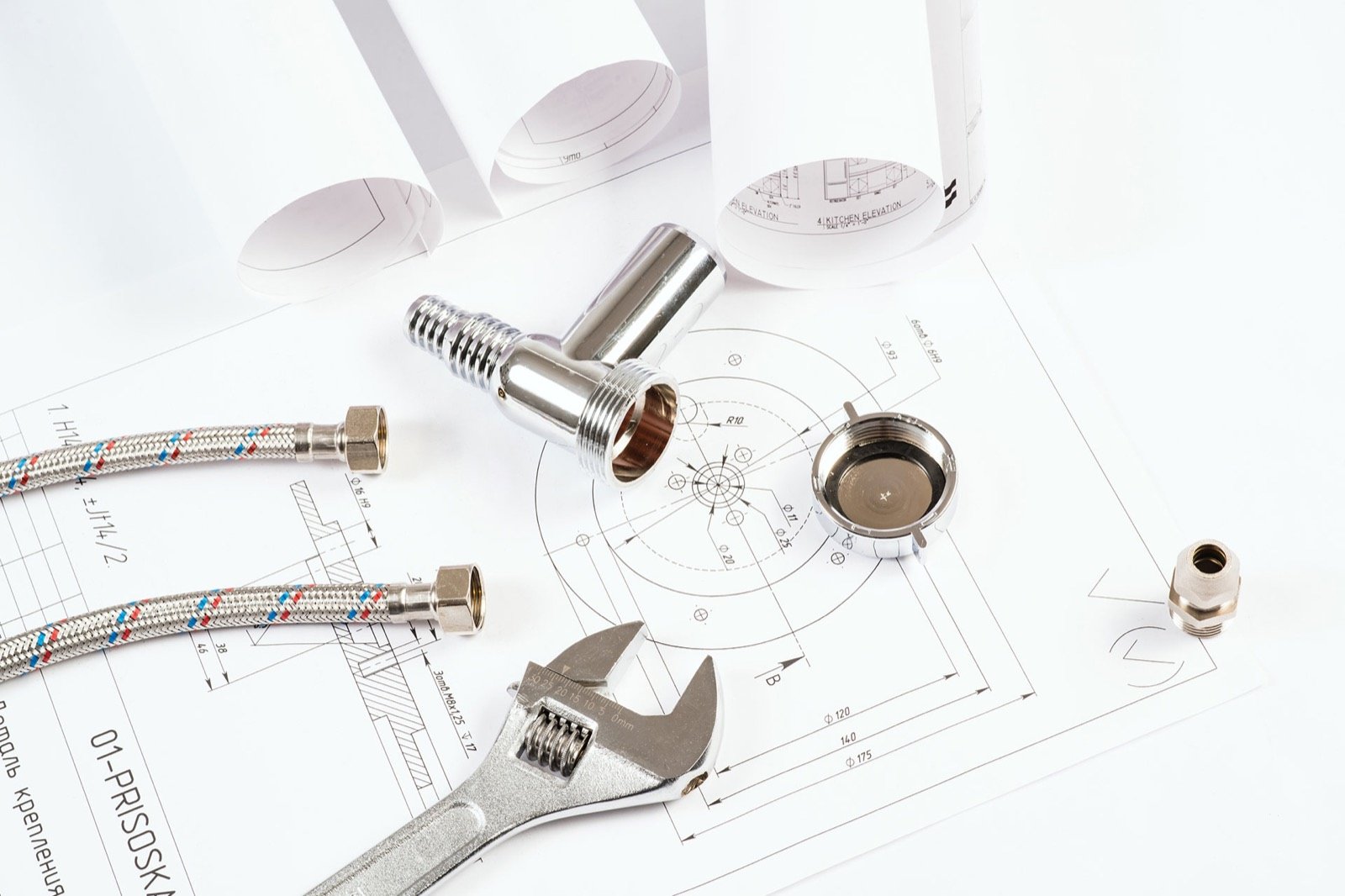 Plumbing fittings, hoses and a wrench on engineering drawings