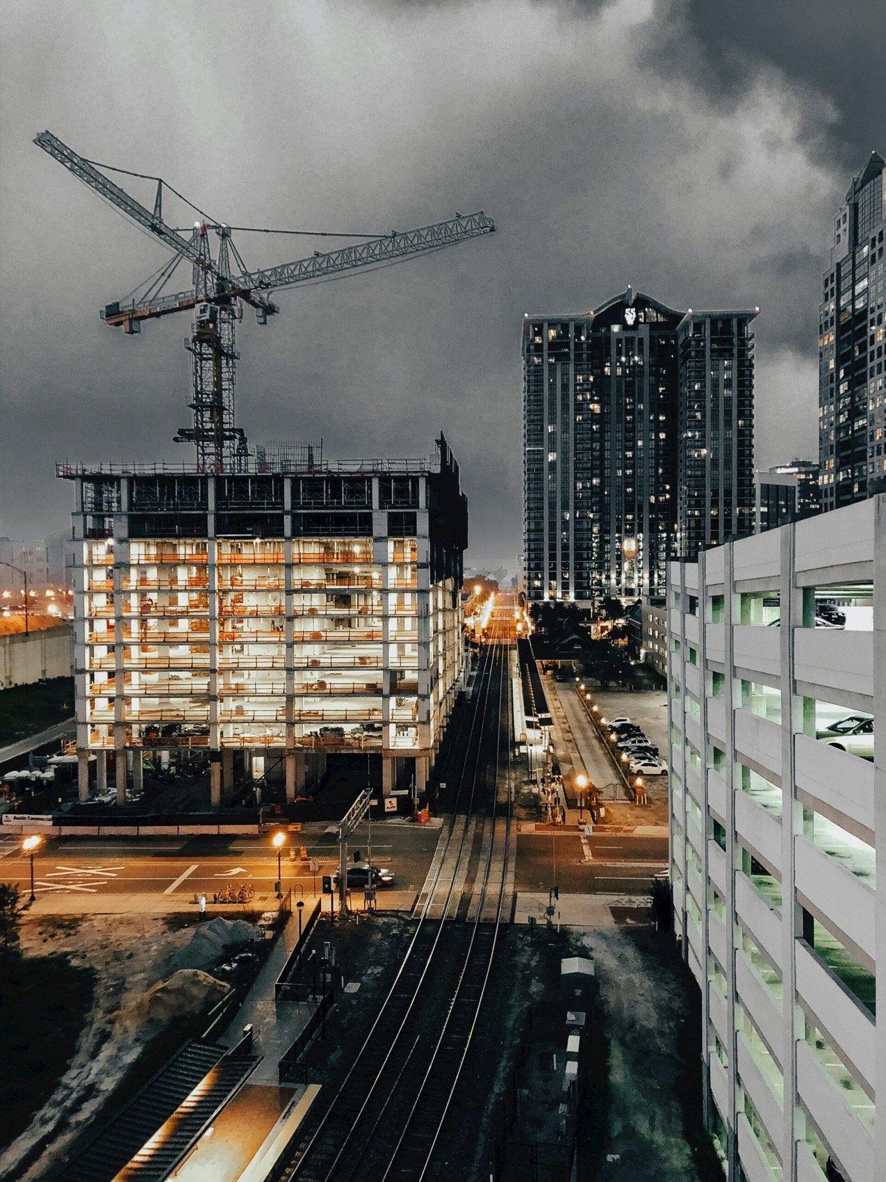 Construction site with cranes and new buildings at dusk